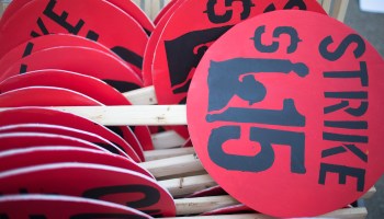 Signs sit in a pile as demonstrators demanding an increase in the minimum wage to $15-dollars-per-hour prepare to march in the streets on April 14, 2016 in Chicago, Illinois.