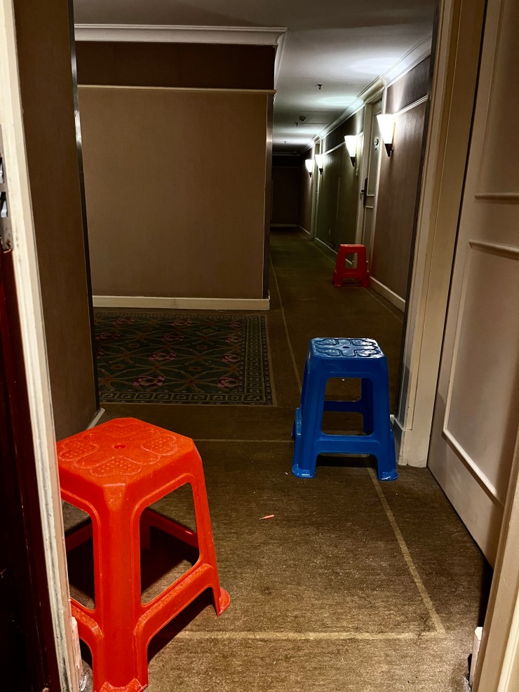 Plastic stools are placed outside quarantine rooms for contactless meal deliveries.  Customers are only allowed to collect meals once they hear an automated message.  (Courtesy of Pack)