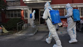 A disinfection squad in Shanghai enters a residential building after a confirmed COVID case.