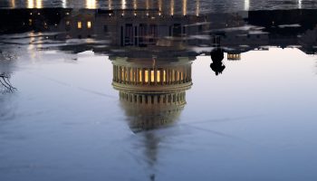 The U.S. Capitol is reflected in the Capitol reflecting pool at dawn.