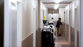 An employee carries a mop in a hotel in Virginia Beach, Virginia, on June 22, 2022.