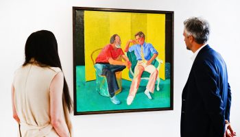 Two people look at David Hockney's "The Conversation."