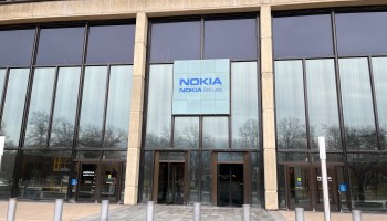 The entrance to Nokia Bell Labs in Murray Hill, New Jersey. A sign with the company name hangs in front of glass windows above a doorway.