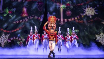 On stage, the Nutcracker and soldiers dance.