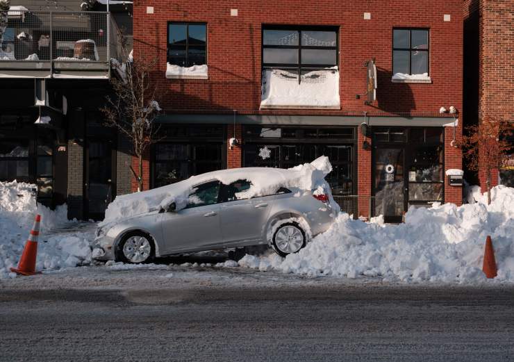 Изоставена кола на Elmwood Avenue в Бъфало, Ню Йорк, 28 декември 2022 г. Много фирми бяха принудени да затворят в дните, които обикновено са натоварени с празнично пазаруване.  (ДЖОЕД ВИЕРА/AFP чрез Getty Images)