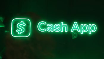 The logo for Cash App is seen in neon lights.