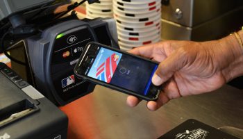 A person uses Apple Pay to pay for concessions at a baseball game.