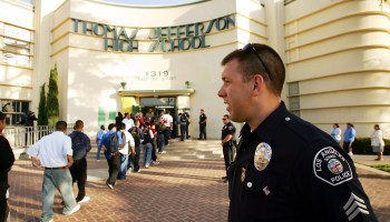 Los Angeles School Police Sgt. Robert Carlborn watches over students lining up to pass through a security check point.
