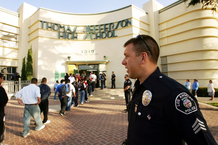 Los Angeles School Police Sgt. Robert Carlborn watches over students lining up to pass through a security check point.