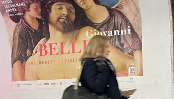 Woman walks past advertising in the Paris subway.