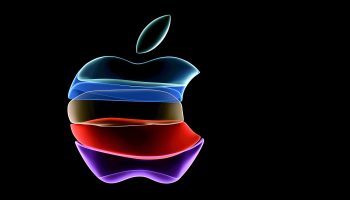 The Apple logo — the silhouette of a partially eaten apple — on a black screen. It is animated and the apple is made of partially transparent color blocks of pink, red, yellow, blue and teal.
