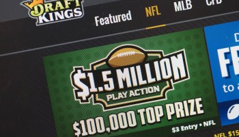 The DraftKings website shows the company's name under a three-pointed crown. Across the top, a list of categories reads: Featured, NFL, MLB and CFB. Under that is a box with a drawing of a football and the words: $1.5 million play action. $100,000 top prize.