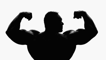 The silhouette of a bodybuilder flexing their biceps.