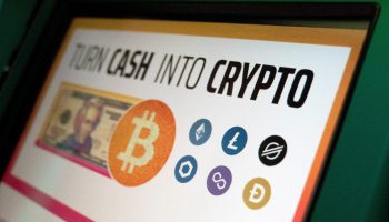 The Bitcoin logo is seen on a Coinstar cryptocurrency ATM at a grocery store. The ATM reads "Turn cash into crypto."