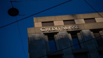 "Credit Suisse" is spelled out in large white letters on a concrete building set against a blue sky at a Geneva branch of the Swiss bank.