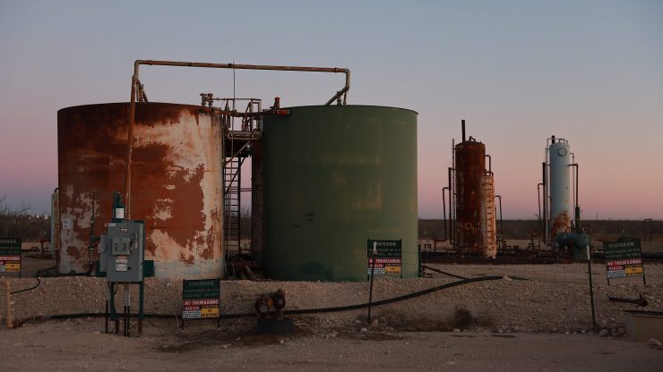 Storage tanks that are part of a system for holding waste water and crude oil are seen in Midland, Texas.