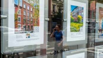 Advertisements for available apartments are posted in the window of a New York City's realtor's office.
