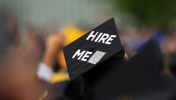 A graduation cap with a QR code and writing that reads, "Hire me"