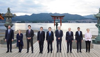 G-7 leaders stand next to each other in Japan, posing for a photo in front of a shrine.