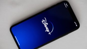 Picture shows the Disney+ logo on blue screen of a cell phone.
