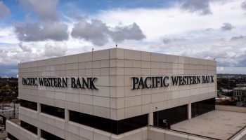 An aerial view of a Pacific Western Bank building on May 4 in Los Angeles against a blue sky with some white and gray clouds.