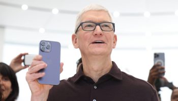 Apple CEO Tim Cook holds up a new, silver iPhone 14 Pro during an Apple special event on in Cupertino, California.