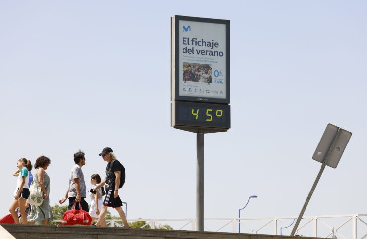 La gente pasa delante de un termómetro gigante que marca 45 grados centígrados.