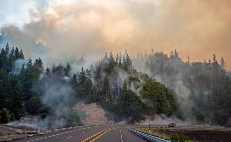 A fire truck drives along Highway 299 as the Carr Fire burns near Whiskeytown, California, in July 2018.